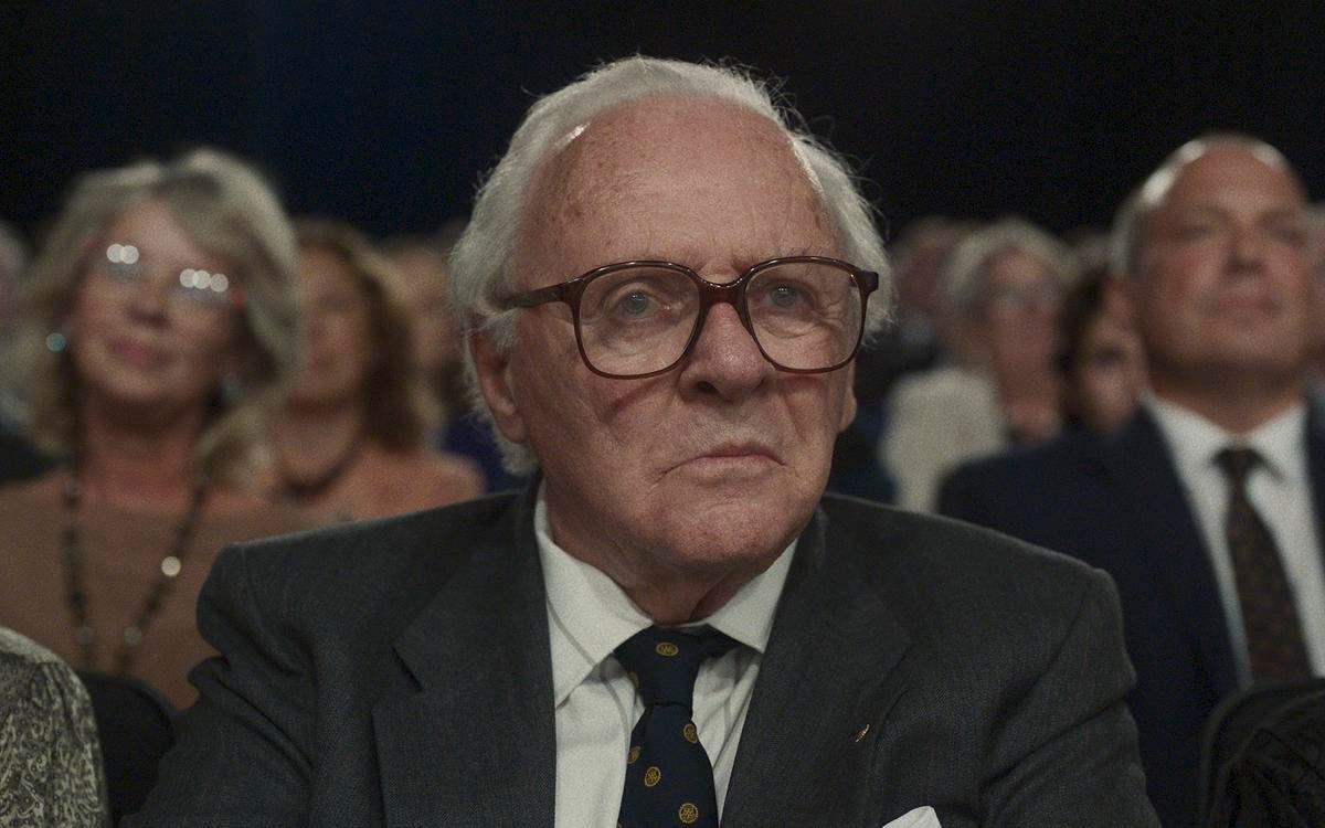 Кадр из фильма «Одна жизнь», седой мужчина в костюме и очках сидит в зрительном зале
