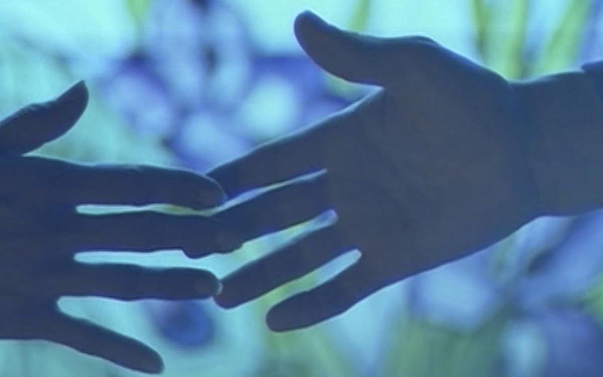 Титульное изображение для страницы события: кадр из фильма «Не подумай, что я кричу», две руки касаются друг друга на сине-зеленом фоне