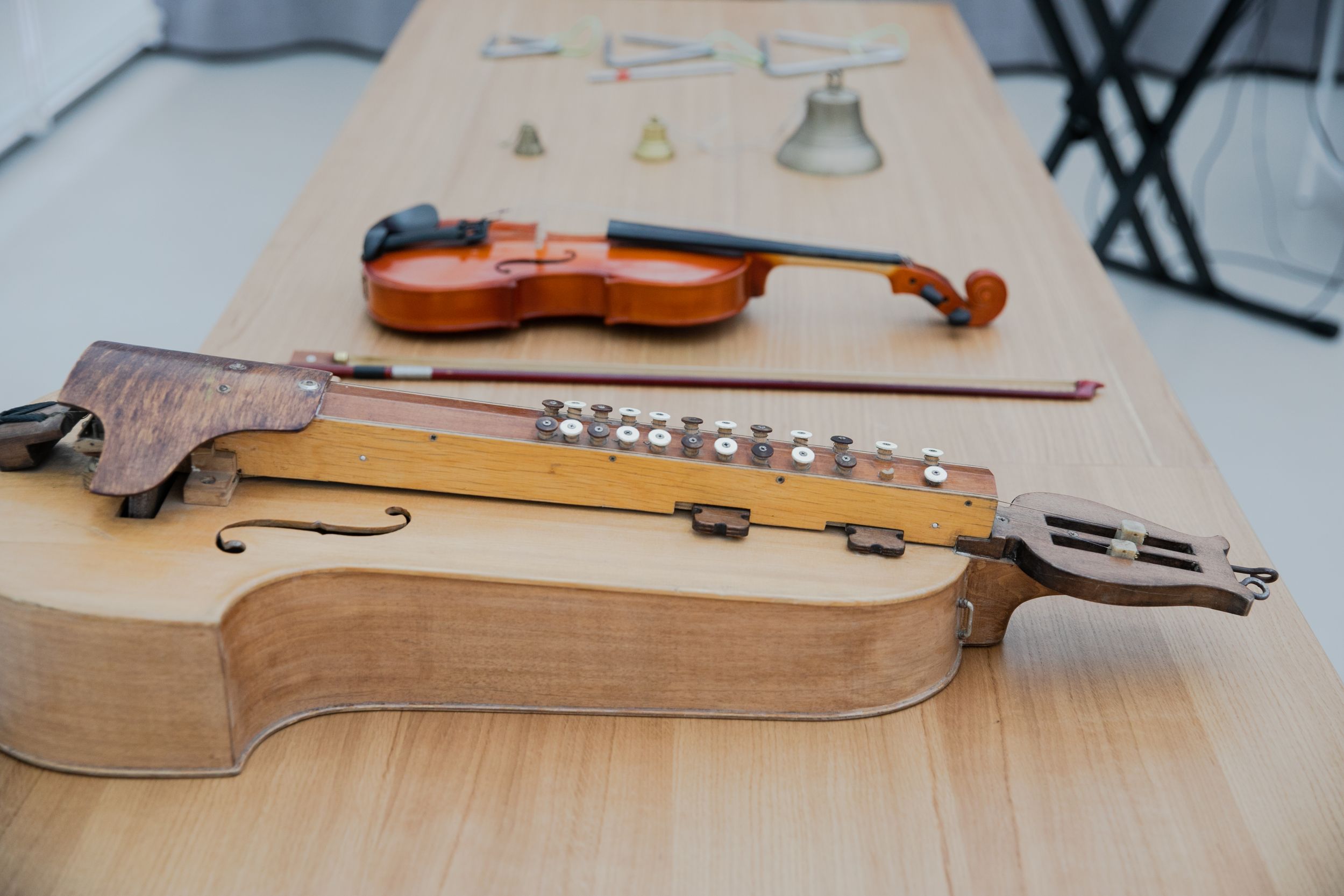 На столе разложены музыкальные инструменты: скрипка, колокольчики, треугольники
