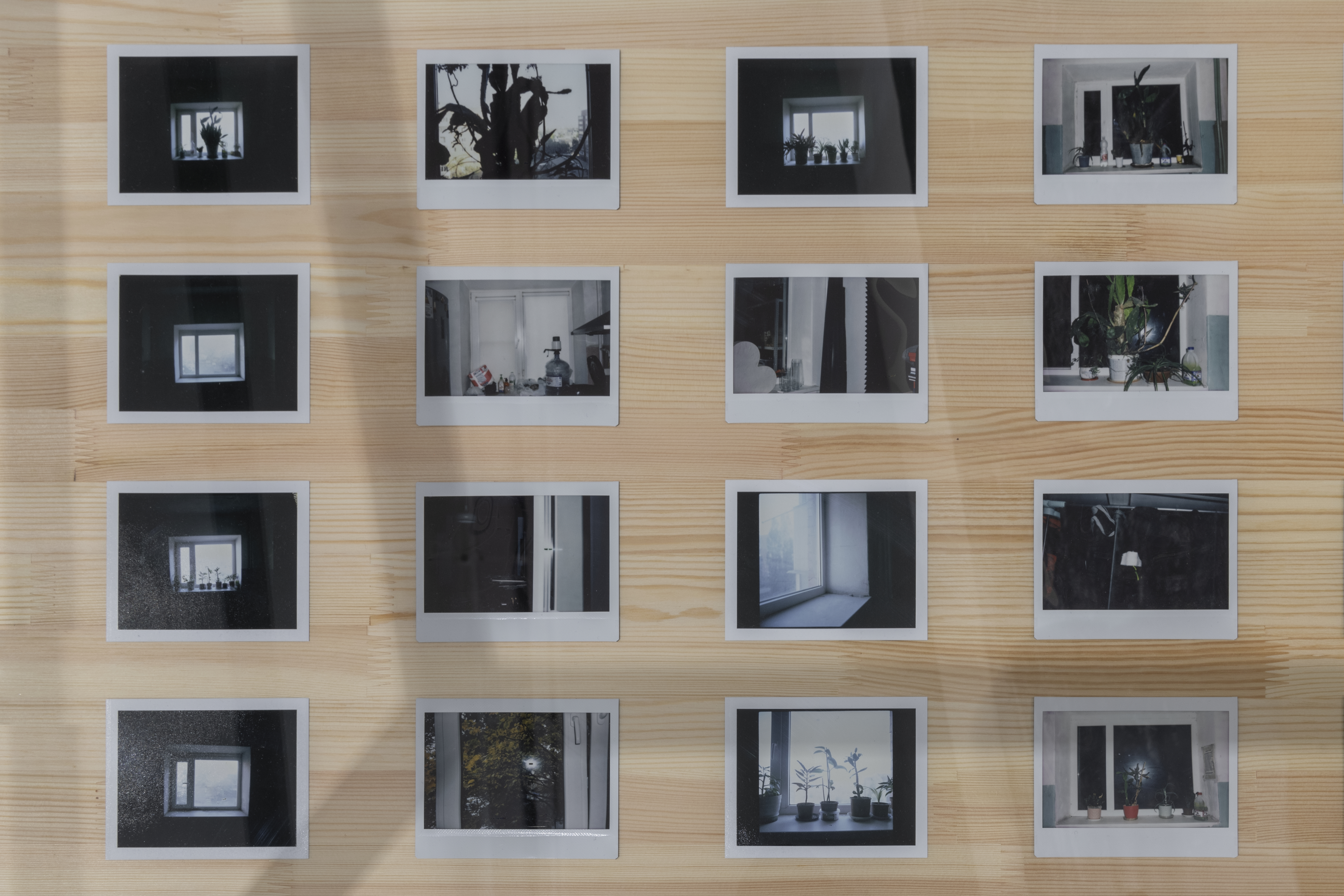 16 прямоугольных черно-белых полароидных фото разложены на столе