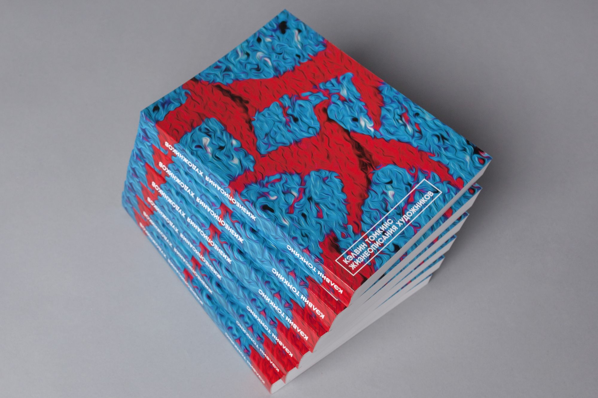 Фотография стопки книг в мягкой обложки с оформлением в голубых и красных тонах