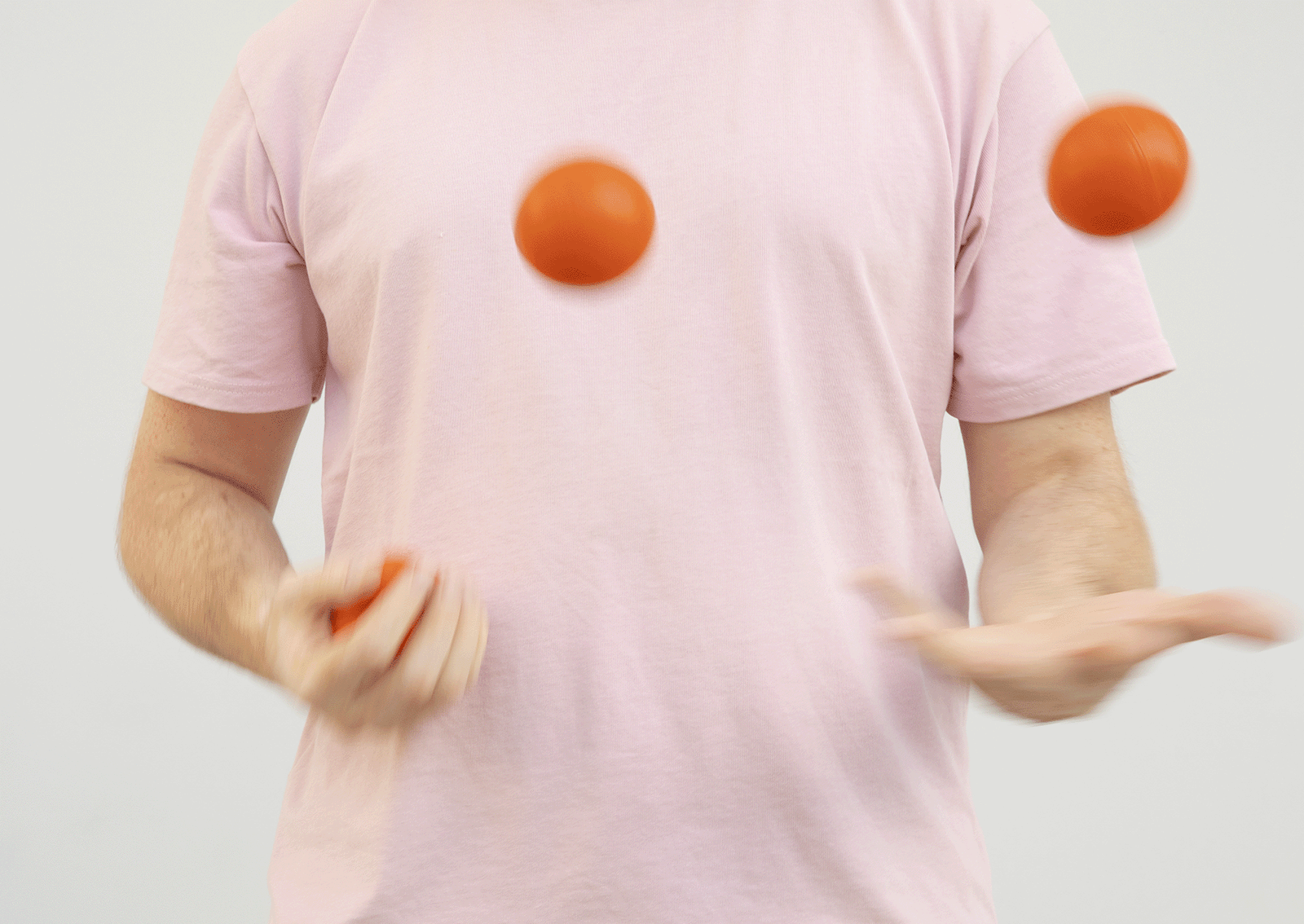 Анимация, человек в розовой футболке жонглирует тремя красными шарами