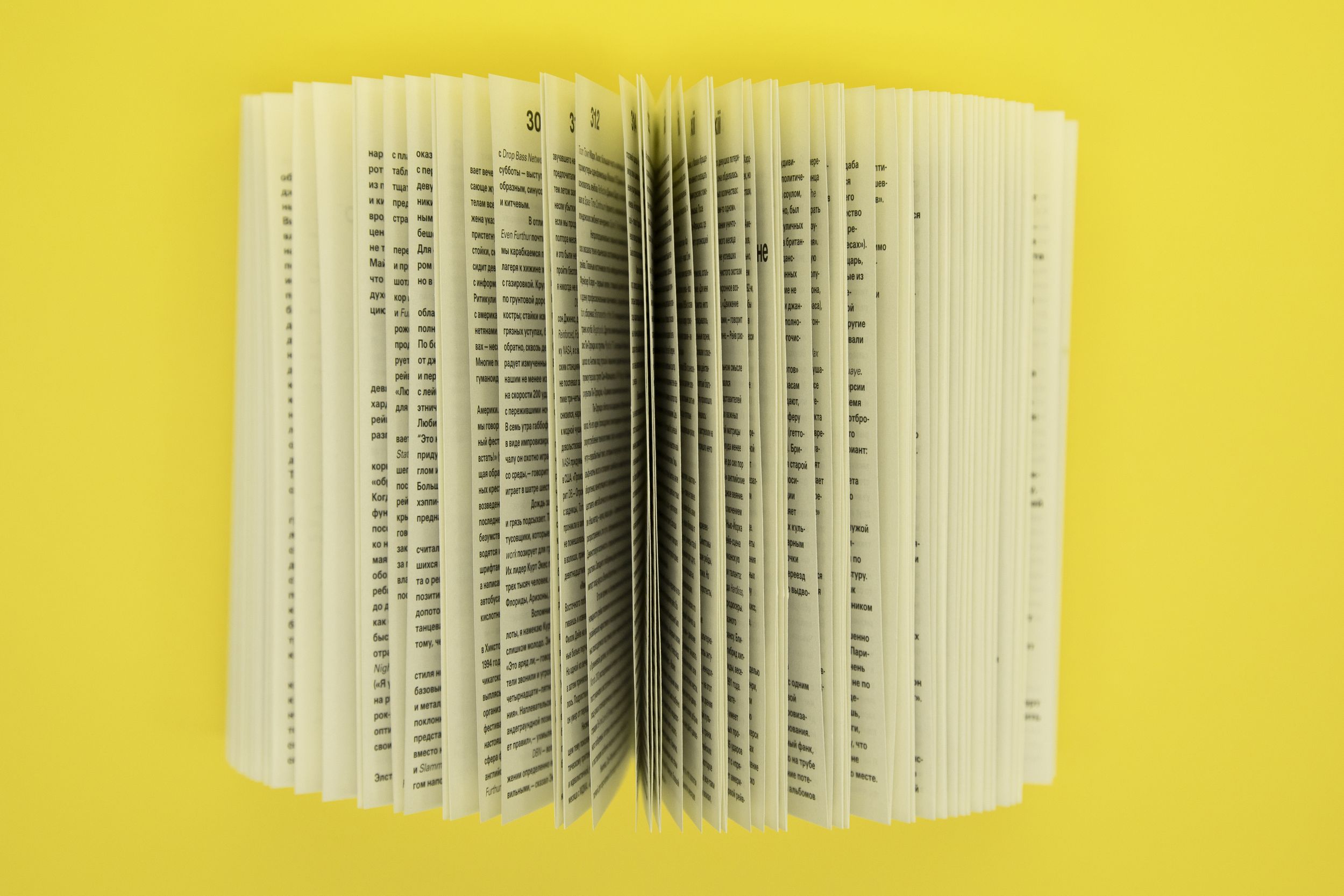  Книга с раскрытыми в разные стороны страницами на желтом фоне
